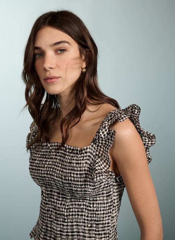 Description\nWe designed this neat-fitting top to go with all manner of summer separates, like white jeans and denim shorts. Fully smocked around the bodice, it hugs the body and is topped with pretty, ruffled straps and a square neckline. So versatile, you could dress it up for evening cocktails with black trousers and hoop earrings.\n\nMade in Europe\nCrafted in yarn-dyed linen\nSimply pulls on\nShort and neat fit\n\n\nSustainable Attributes:\n Low Water Use Natural fibres Ethically made   Vegan  \nDetails\nModel is 5'10 (177cm) and is wearing a UK 10100% Linen Delicate Machine Wash - 30°Product code: TP40701-BWG Back shoulder at neck to hem - 45cm (17 3/4))