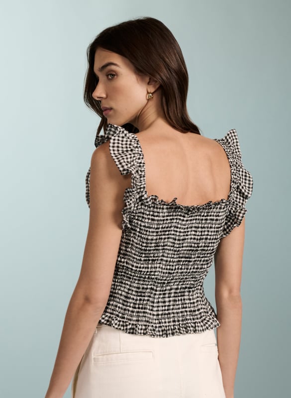 Description\nWe designed this neat-fitting top to go with all manner of summer separates, like white jeans and denim shorts. Fully smocked around the bodice, it hugs the body and is topped with pretty, ruffled straps and a square neckline. So versatile, you could dress it up for evening cocktails with black trousers and hoop earrings.\n\nMade in Europe\nCrafted in yarn-dyed linen\nSimply pulls on\nShort and neat fit\n\n\nSustainable Attributes:\n Low Water Use Natural fibres Ethically made   Vegan  \nDetails\nModel is 5'10 (177cm) and is wearing a UK 10100% Linen Delicate Machine Wash - 30°Product code: TP40701-BWG Back shoulder at neck to hem - 45cm (17 3/4))