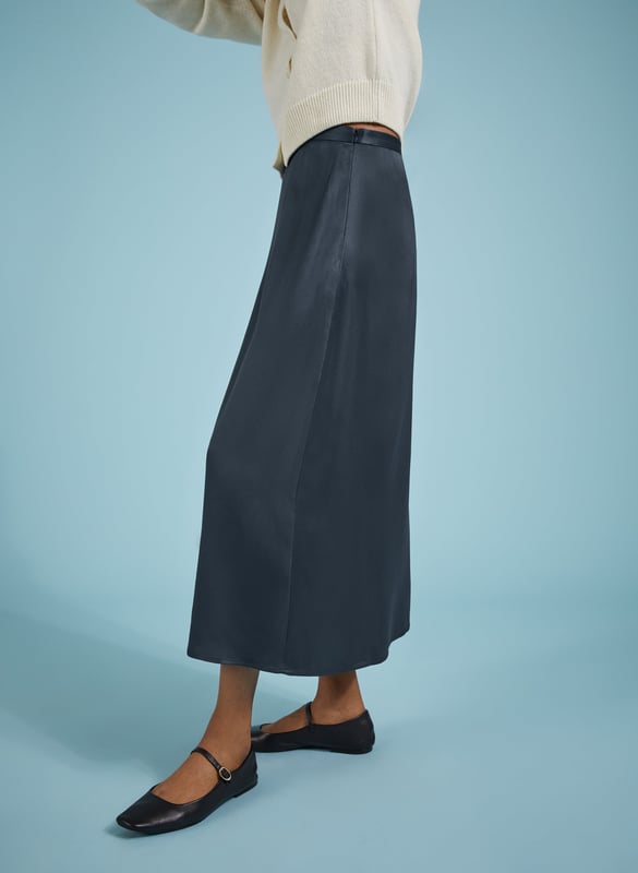 Description\nFits true to size, we suggest ordering your usual size.\nSlip skirts are enjoying a moment, and Doris is the easiest and most impactful style to update your wardrobe with. Crafted in satin-back crepe Ecojilin viscose, this style comes in a simple column shape, and features hidden elastic in the back of the waistband for comfort. In classic navy, it will add a considered twist to plain white tees or jumpers, and can easily be dressed-up with a blouse or camisole for nights out.\n\nMade in Europe\nCrafted in responsibly sourced Ecojilin viscose \nLong length\nFastens with an invisible side zip\nHidden elastic at back waist\n\n\nSustainable Attributes:\n  Low impact  Low Water Use   Recycled Fibres   Ethically made  Low Carbon \n\nDetails\nModel is 5'10 (177cm) and is wearing a UK 10100% Ecojilin ViscoseDry Clean OnlyProduct Code: SK40199-CLNCentre back waist to hem - 84cm (33)