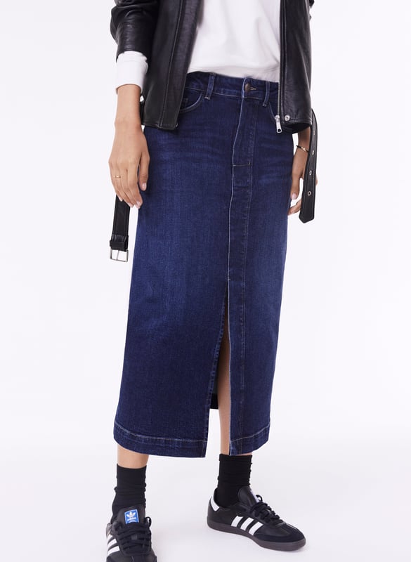 Description\nFits true to size, we suggest ordering your usual size.\nThe hot-ticket item right now according to our Design Director Natalie. A long-line denim skirt. In organic cotton of course. Emilia is a cool alternative to jeans, with a split up the front for a flash of leg and easy movement. It’s a versatile piece which hugs the waist and hips before tapering out into a chic column shape. So versatile, you can dress it up with loafers and a shirt, or down with a sweater and sneakers.\n\nCrafted in organic cotton denim\nLong midi length\nFront split detail\nZip button and fly fastening\nClassic jeans pockets\n\n\nSustainable Attributes:\n  Made in Europe    Natural fibres    Organic    Ethically made    Vegan    Low Carbon    Raw Material Traced \n\nDetails\nModel is 5'10 (177cm) and is wearing a UK 1099% Organic Cotton, 1% ElastaneDelicate Machine Wash - 30°Product code: SK40163-DIN Centre back waist to hem - 81cm (31 7/8)