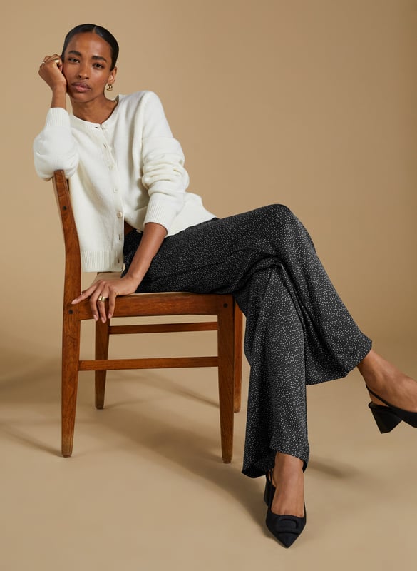 Description\nFits true to size, we suggest ordering your usual size.\nAdd a playful twist to your wardrobe with the Mandy Satin Trousers. Featuring a chic black mini spot print on a satin finish, these wide-leg trousers are perfect for pairing with crisp white blouses or oversized tees. But our favourite way to style them is with the matching Saffron Satin Blouse for a chic, coordinated look. Cut in a wide-leg, pyjama-style silhouette, these trousers are perfect for bringing a bit of effortless elegance to your day.\n\nMade in Europe\nCrafted in a recycled satin blend\nElasticated waist with draw-cord\nSide slash pockets and back patch pockets\nWide-leg, relaxed fit\nBlack piping detail down each leg\nMatching shirt available\n\n\nSustainable Attributes:\n  Low impact  Low Water Use   Natural fibres   Recycled Fibres   Ethically made  Low Carbon \n\nDetails\nModel is 5'10 (177cm) and is wearing a UK 1049% Lenzing™ EcoVero™ Viscose, 51% Recycled ViscoseDelicate Machine Wash 30˚Wash Inside Out - Wash Dark Colours SeparatelyProduct Code: TR40313-BNSInside leg - 77.5cm (30 1/2)