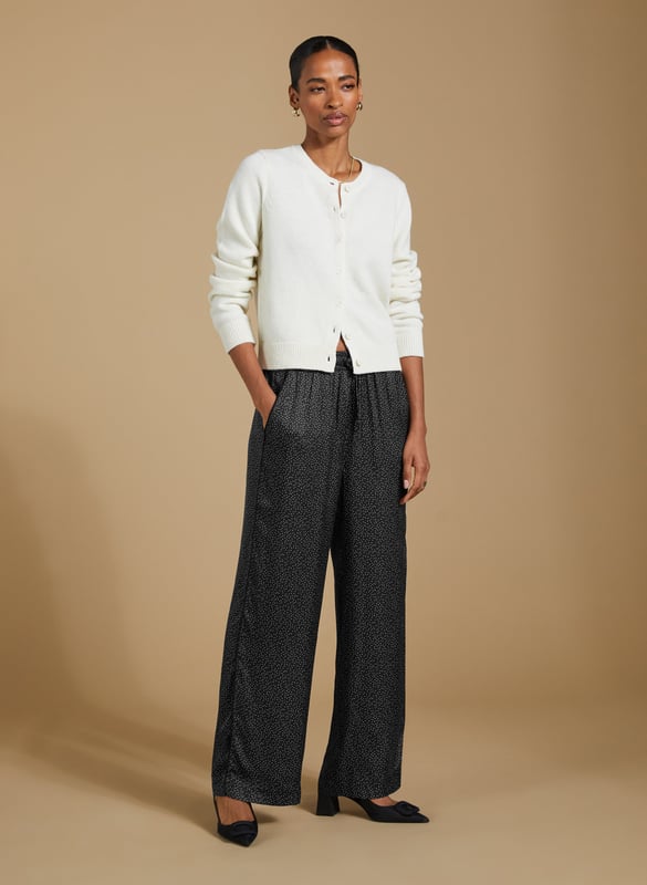 Description\nFits true to size, we suggest ordering your usual size.\nAdd a playful twist to your wardrobe with the Mandy Satin Trousers. Featuring a chic black mini spot print on a satin finish, these wide-leg trousers are perfect for pairing with crisp white blouses or oversized tees. But our favourite way to style them is with the matching Saffron Satin Blouse for a chic, coordinated look. Cut in a wide-leg, pyjama-style silhouette, these trousers are perfect for bringing a bit of effortless elegance to your day.\n\nMade in Europe\nCrafted in a recycled satin blend\nElasticated waist with draw-cord\nSide slash pockets and back patch pockets\nWide-leg, relaxed fit\nBlack piping detail down each leg\nMatching shirt available\n\n\nSustainable Attributes:\n  Low impact  Low Water Use   Natural fibres   Recycled Fibres   Ethically made  Low Carbon \n\nDetails\nModel is 5'10 (177cm) and is wearing a UK 1049% Lenzing™ EcoVero™ Viscose, 51% Recycled ViscoseDelicate Machine Wash 30˚Wash Inside Out - Wash Dark Colours SeparatelyProduct Code: TR40313-BNSInside leg - 77.5cm (30 1/2)