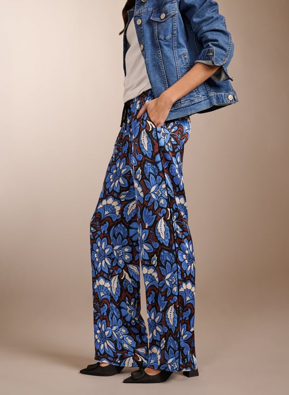 Description\nA building blend of pattern and colour, the Mandy are surprisingly versatile. Guaranteed to lend a touch of fun to casual tees, they look chic with a crisp white blouse. But our favourite way to style them is with the matching Gloria blouse for a fun and fearless outfit. Cut as a wide-leg, they are the ultimate spring-in-your-step piece. Enjoy for years. \n\nMade in Europe\nCrafted from a recycled satin blend \nElasticated waist with draw-cord \nSide slash pockets  \nWide-leg, relaxed fit \nBlack piping detail down each leg \nMatching top available \n\n\nSustainable Attributes:\n \n\n Low impact \n\n Low Water Use\n \n Recycled Fibres \n\n Ethically made\n\n Vegan \n\n\n\nDetails\n Model is 5'10 (177cm) and is wearing a UK 10\n49% LENZING™ ECOVERO™ Viscose, 51% Recycled Viscose\nDelicate Machine Wash 30˚\nProduct code: TR40313-BFA\nInside leg - 77cm (30 1/4)