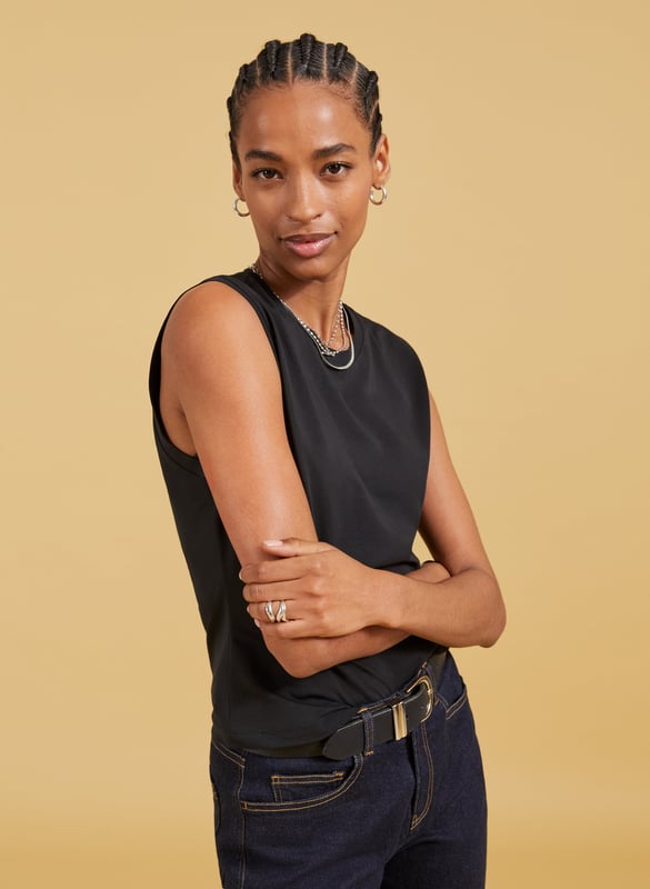 Description\nSlim fit. For a looser look, we suggest sizing up from your usual size.\nAmber isn’t a vest top nor a classic tee - she’s perfectly in-between. Cut for a neat fit and designed to just meet the top of your jeans and chinos, it’s a casual basic you’ll wonder how you got by without. In organic stretch cotton, it’s comfortable too. Prepare to wear on repeat.\n\nMade in Europe\nCrafted in organic stretch cotton\nFitted\nShaped armholes\n\n\nSustainable Attributes:\n\n    Low Impact \n  \n Low Water Use \n    Natural fibres \n   Ethically made\n    Low Carbon \n  Organic \n\nDetails\n95% Organic Cotton, 5% Elastane Delicate Machine Wash - 30°Product Code: TP40715-BLKBack shoulder at neck to hem - 53cm (20 7/8)