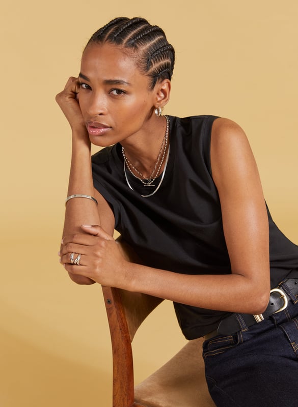 Description\nSlim fit. For a looser look, we suggest sizing up from your usual size.\nAmber isn’t a vest top nor a classic tee - she’s perfectly in-between. Cut for a neat fit and designed to just meet the top of your jeans and chinos, it’s a casual basic you’ll wonder how you got by without. In organic stretch cotton, it’s comfortable too. Prepare to wear on repeat.\n\nMade in Europe\nCrafted in organic stretch cotton\nFitted\nShaped armholes\n\n\nSustainable Attributes:\n\n    Low Impact \n  \n Low Water Use \n    Natural fibres \n   Ethically made\n    Low Carbon \n  Organic \n\nDetails\n95% Organic Cotton, 5% Elastane Delicate Machine Wash - 30°Product Code: TP40715-BLKBack shoulder at neck to hem - 53cm (20 7/8)