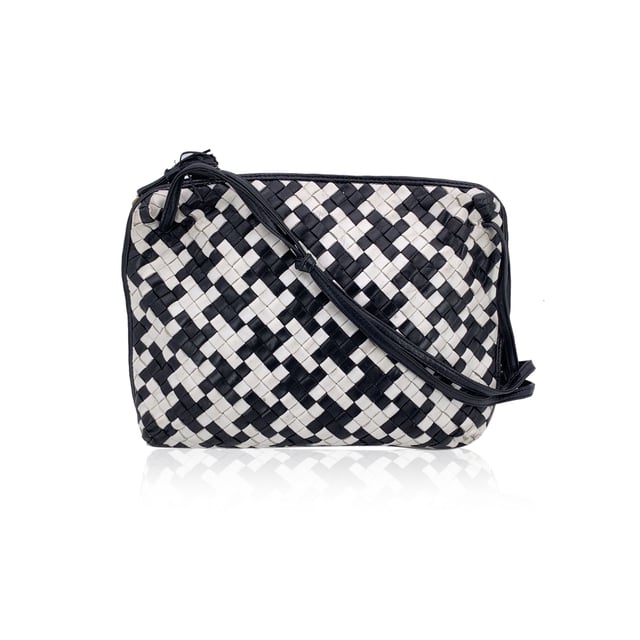 VINTAGE, RRP AS NEW
A rare find for true connoisseurs of vintage luxury, this Bottega Veneta Nodini shoulder bag is a stunning example of the brand's mastery in leather artistry. Crafted from supple nappa leather, its iconic Intrecciato weave is reimagined in a striking black-and-white pied-de-poule pattern-bold yet elegant, with a graphic rhythm that speaks to timeless Italian sophistication.  The compact silhouette features an upper zipper closure that opens to reveal a sleek black satin lining and a practical side zip pocket for your essentials. Inside, the "Bottega Veneta - Made in Italy" tag and the original certification label affirm its ity and heritage.  Both distinctive and understated, this vintage Nodini is more than just a bag-it's a piece of wearable craftsmanship, echoing the quiet luxury and artisanal spirit that define Bottega Veneta's legacy. Condition Rating: B - VERY GOOD CONDITIONCondition Details: Gently used. Some darkness on white leather. Some wear of use on bottom corners. Please check the photos carefully and ask if you need to know more details or if you have any doubts.Measurements (cm):Depth: 6.4Height: 20.3Length: 30.5Other Details: Dustbag? NoKeys? NoBox? No Measurments:  width: 64 mm length: 305 mm height: 203 mm