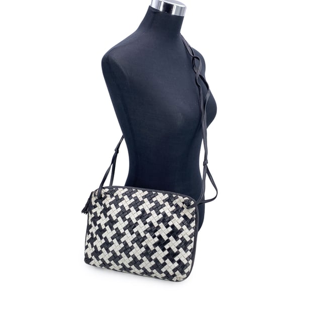 VINTAGE, RRP AS NEW
A rare find for true connoisseurs of vintage luxury, this Bottega Veneta Nodini shoulder bag is a stunning example of the brand's mastery in leather artistry. Crafted from supple nappa leather, its iconic Intrecciato weave is reimagined in a striking black-and-white pied-de-poule pattern-bold yet elegant, with a graphic rhythm that speaks to timeless Italian sophistication.  The compact silhouette features an upper zipper closure that opens to reveal a sleek black satin lining and a practical side zip pocket for your essentials. Inside, the "Bottega Veneta - Made in Italy" tag and the original certification label affirm its ity and heritage.  Both distinctive and understated, this vintage Nodini is more than just a bag-it's a piece of wearable craftsmanship, echoing the quiet luxury and artisanal spirit that define Bottega Veneta's legacy. Condition Rating: B - VERY GOOD CONDITIONCondition Details: Gently used. Some darkness on white leather. Some wear of use on bottom corners. Please check the photos carefully and ask if you need to know more details or if you have any doubts.Measurements (cm):Depth: 6.4Height: 20.3Length: 30.5Other Details: Dustbag? NoKeys? NoBox? No Measurments:  width: 64 mm length: 305 mm height: 203 mm