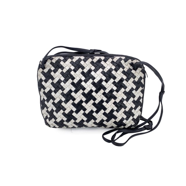 VINTAGE, RRP AS NEW
A rare find for true connoisseurs of vintage luxury, this Bottega Veneta Nodini shoulder bag is a stunning example of the brand's mastery in leather artistry. Crafted from supple nappa leather, its iconic Intrecciato weave is reimagined in a striking black-and-white pied-de-poule pattern-bold yet elegant, with a graphic rhythm that speaks to timeless Italian sophistication.  The compact silhouette features an upper zipper closure that opens to reveal a sleek black satin lining and a practical side zip pocket for your essentials. Inside, the "Bottega Veneta - Made in Italy" tag and the original certification label affirm its ity and heritage.  Both distinctive and understated, this vintage Nodini is more than just a bag-it's a piece of wearable craftsmanship, echoing the quiet luxury and artisanal spirit that define Bottega Veneta's legacy. Condition Rating: B - VERY GOOD CONDITIONCondition Details: Gently used. Some darkness on white leather. Some wear of use on bottom corners. Please check the photos carefully and ask if you need to know more details or if you have any doubts.Measurements (cm):Depth: 6.4Height: 20.3Length: 30.5Other Details: Dustbag? NoKeys? NoBox? No Measurments:  width: 64 mm length: 305 mm height: 203 mm