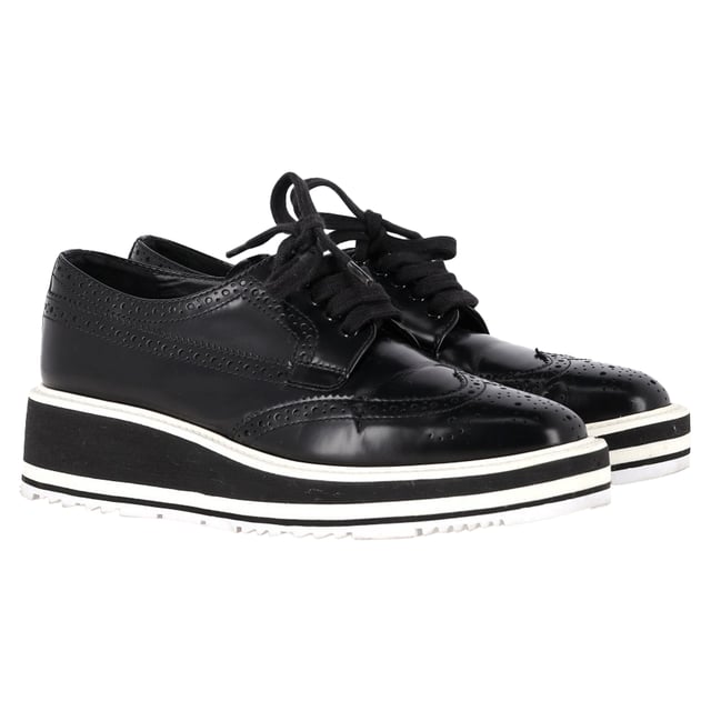 Empfohlener Verkaufspreis
Dieses luxuriöse Paar von Prada ist einfach atemberaubend! Die Derby-Sneaker aus Leder sind hochwertig verarbeitet und mit Schnürung und Flügelkappen-Details versehen. Bequeme Innensohlen und klobige Plateaus runden dieses Must-have ab!

Prada Plateau-Brogues aus schwarzem Leder
Zustand: Sehr gut
Gebrauchsspuren: Leichte Gebrauchsspuren, wenig getragen, aber sehr gut erhalten. Leichte Gebrauchsspuren und Knicke an Sohlen und Absatz.
Verpackung: Staubbeutel
Farbe: Schwarz
Material: Leder
Größe: EU 36,5
Maße: Absatzhöhe: 45; Innensohlenlänge: 290
Artikelnummer: TONPUGBSH485012W