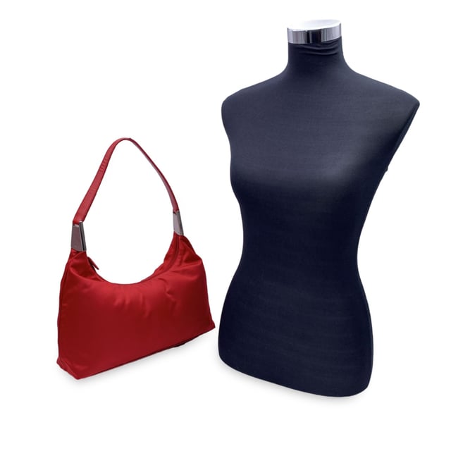 Empfohlener Verkaufspreis
Markante, lässige und unverkennbare Prada-Tasche – diese Vintage-Hobo-Schultertasche fängt die Essenz des Minimalismus der frühen 2000er-Jahre mit einem Hauch von sattem Rot ein. Gefertigt aus dem markentypischen Tessuto-Nylon-Canvas ist sie leicht und dennoch luxuriös, abgerundet durch einen eleganten Schultergurt aus echtem Leder und silberfarbene Metallteile, die für den perfekten Glanz sorgen. Die klassische Hobo-Silhouette wird durch einen oberen Reißverschluss gesichert, der ein leuchtend rotes Canvas-Futter und eine praktische seitliche Reißverschlusstasche freigibt. Im Inneren zeugt das Etikett „Prada Milano – Made in Italy“ von ihrer Tradition und der beständigen italienischen Handwerkskunst. Ein zeitloses Basic mit sportlich-schickem Flair – diese Prada Hobo ist für alle gemacht, die ihre Mode funktional und dennoch kantig mögen. Zustandsbewertung: A – AUSGEZEICHNET. Zustandsdetails: Wenig getragen. Bitte sehen Sie sich die Fotos sorgfältig an und fragen Sie nach, wenn Sie weitere Details benötigen oder Zweifel haben. Maße (cm): Tiefe: 10,2 Höhe: 22,9 Länge: 34,3 Weitere Details: Staubbeutel? Nein Schlüssel? Nein Box? Nein Maße: Breite: 102 mm Länge: 343 mm Höhe: 229 mm