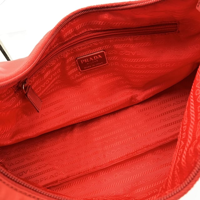 Empfohlener Verkaufspreis
Markante, lässige und unverkennbare Prada-Tasche – diese Vintage-Hobo-Schultertasche fängt die Essenz des Minimalismus der frühen 2000er-Jahre mit einem Hauch von sattem Rot ein. Gefertigt aus dem markentypischen Tessuto-Nylon-Canvas ist sie leicht und dennoch luxuriös, abgerundet durch einen eleganten Schultergurt aus echtem Leder und silberfarbene Metallteile, die für den perfekten Glanz sorgen. Die klassische Hobo-Silhouette wird durch einen oberen Reißverschluss gesichert, der ein leuchtend rotes Canvas-Futter und eine praktische seitliche Reißverschlusstasche freigibt. Im Inneren zeugt das Etikett „Prada Milano – Made in Italy“ von ihrer Tradition und der beständigen italienischen Handwerkskunst. Ein zeitloses Basic mit sportlich-schickem Flair – diese Prada Hobo ist für alle gemacht, die ihre Mode funktional und dennoch kantig mögen. Zustandsbewertung: A – AUSGEZEICHNET. Zustandsdetails: Wenig getragen. Bitte sehen Sie sich die Fotos sorgfältig an und fragen Sie nach, wenn Sie weitere Details benötigen oder Zweifel haben. Maße (cm): Tiefe: 10,2 Höhe: 22,9 Länge: 34,3 Weitere Details: Staubbeutel? Nein Schlüssel? Nein Box? Nein Maße: Breite: 102 mm Länge: 343 mm Höhe: 229 mm