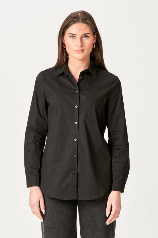 Experimenta la elegancia atemporal de la Camisa Ida en negro para mujer. Esta camisa combina un estilo moderno con la comodidad clásica, perfecta para los armarios del hogar y ocasiones formales. Confeccionado con una suave mezcla de 97 % algodón y 3 % elastano, ofrece un ajuste cómodo que se mueve contigo. Ya sea un día ajetreado en la oficina o un fin de semana relajado en casa, la camisa Ida en negro es el complemento perfecto para tu guardarropa que elevará tu estilo sin esfuerzo.