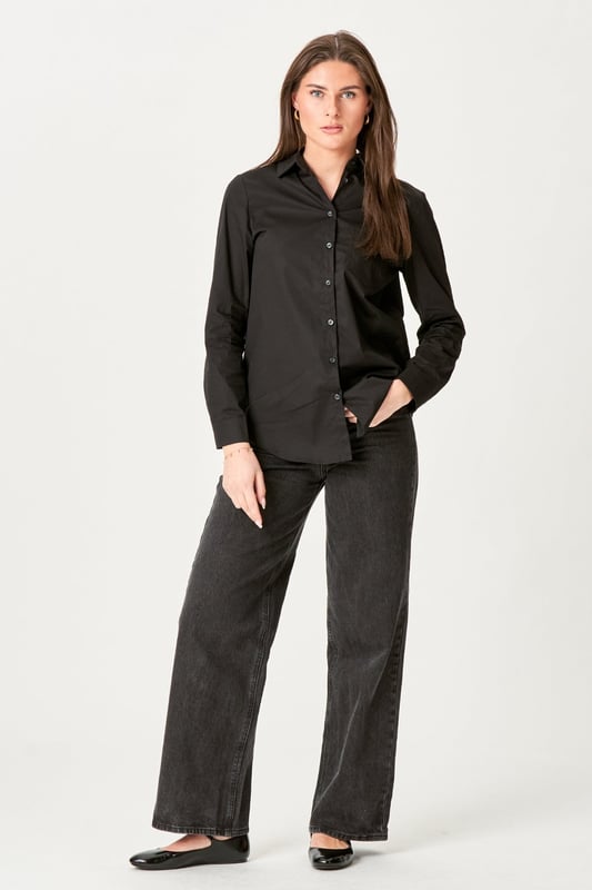 Experimenta la elegancia atemporal de la Camisa Ida en negro para mujer. Esta camisa combina un estilo moderno con la comodidad clásica, perfecta para los armarios del hogar y ocasiones formales. Confeccionado con una suave mezcla de 97 % algodón y 3 % elastano, ofrece un ajuste cómodo que se mueve contigo. Ya sea un día ajetreado en la oficina o un fin de semana relajado en casa, la camisa Ida en negro es el complemento perfecto para tu guardarropa que elevará tu estilo sin esfuerzo.
