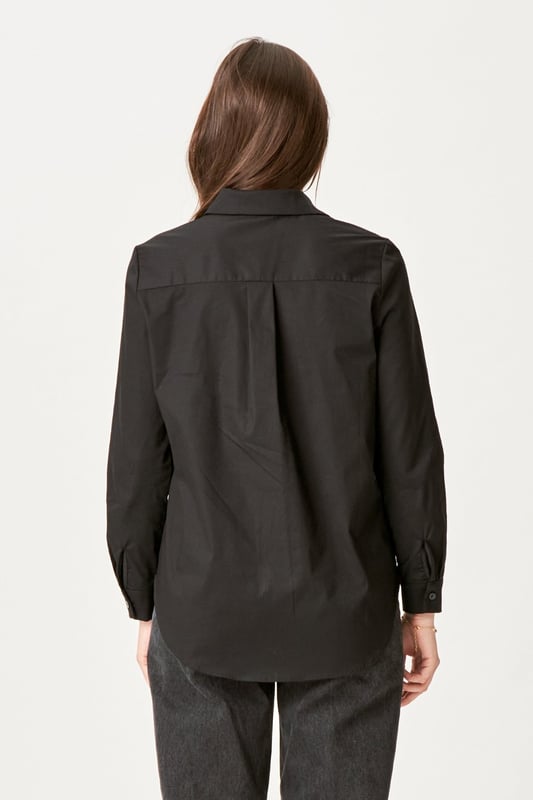 Experimenta la elegancia atemporal de la Camisa Ida en negro para mujer. Esta camisa combina un estilo moderno con la comodidad clásica, perfecta para los armarios del hogar y ocasiones formales. Confeccionado con una suave mezcla de 97 % algodón y 3 % elastano, ofrece un ajuste cómodo que se mueve contigo. Ya sea un día ajetreado en la oficina o un fin de semana relajado en casa, la camisa Ida en negro es el complemento perfecto para tu guardarropa que elevará tu estilo sin esfuerzo.