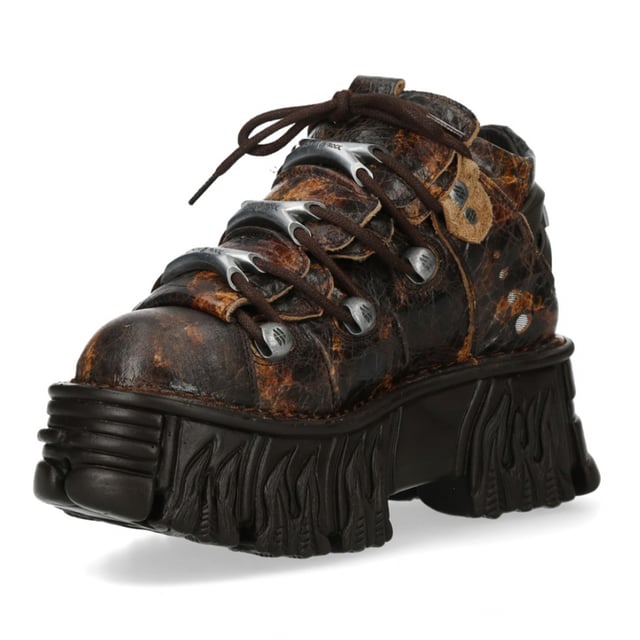Aardse tinten ontmoeten een gothic randje in de New Rock M-106-C194 laarzen uit de Metallic Collectie. Deze enkellaarsjes zijn gemaakt van rijk bruin rundleer met een premium kalfsleren voering en combineren een punk-geïnspireerd design met de klassieke duurzaamheid van New Rock. Een platte, dikke zool met een hak van 7 cm en een plateau van 4 cm zorgt voor extra hoogte zonder in te leveren op comfort. Afgewerkt met een vetersluiting en robuuste details is deze unisex stijl perfect voor wie van gedurfde, alternatieve mode houdt. Belangrijkste kenmerken: Materiaal (buitenkant): Rundleer Materiaal (binnenkant): Kalfsleer Hakhoogte: 7 cm Plateauhoogte: 4 cm Zoolmateriaal: PU Ultra Sluiting: Veters (koord) Schachthoogte: 10 cm Stijl: Gothic, Heavy, Punk, Rock Ontwerp: Unisex (geschikt voor alle geslachten)