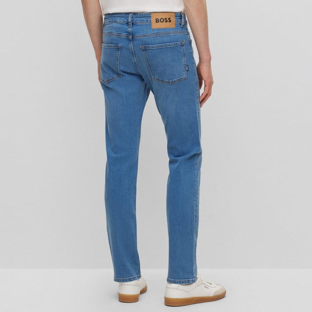 Men's Boss Delaware3-1 Slim-Fit Jeans. Slim Fit Jeans with a modern feel, borrowing the best elements of denim to create a pair that is simultaneously functional and fashionable. This pair features a blue wash design with tonal hardware logo at front pocket and distressed logo at rear waistband. Material: 99% Cotton, 1% Elastane. Ref: 50496102445.