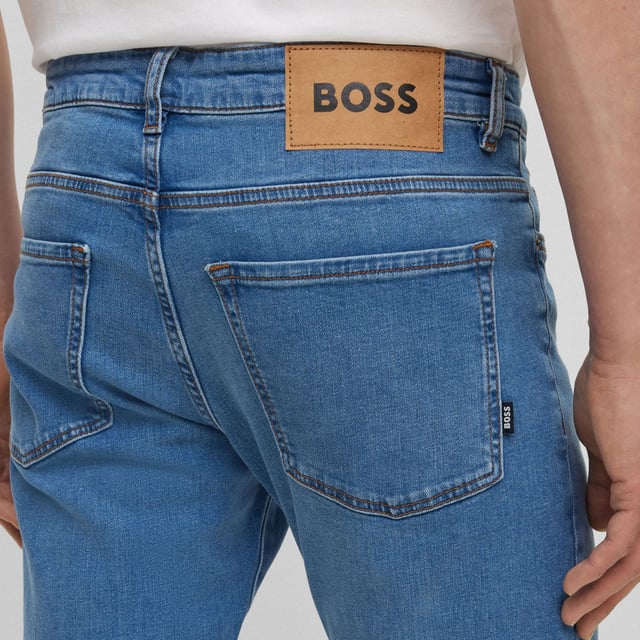Men's Boss Delaware3-1 Slim-Fit Jeans. Slim Fit Jeans with a modern feel, borrowing the best elements of denim to create a pair that is simultaneously functional and fashionable. This pair features a blue wash design with tonal hardware logo at front pocket and distressed logo at rear waistband. Material: 99% Cotton, 1% Elastane. Ref: 50496102445.