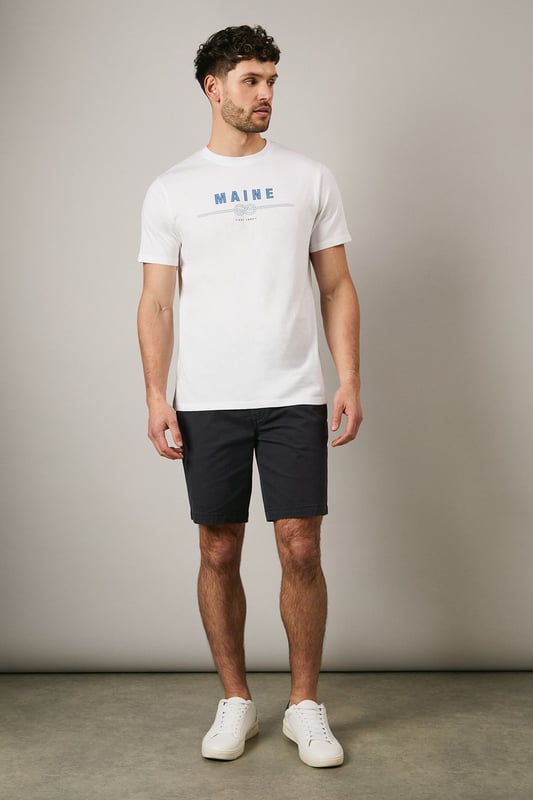 Soft jersey cotton t-shirt featuring the distinctive Maine rope graphic print
        Classic crew neckline with ribbed trim for a comfortable fit
        Short sleeves with clean-finished edges for everyday comfort
        Relaxed yet structured silhouette that maintains its shape throughout the day
        Versatile design that pairs effortlessly with both casual and smart-casual attire
    
    This Maine graphic t-shirt combines simplicity with subtle nautical flair, making it a wardrobe essential for the modern gent. The distinctive rope design adds character without overwhelming, perfect for those who appreciate understated style. Pair with dark chino shorts and trainers as shown for a refined summer look, or layer under an unstructured blazer with tailored trousers for smart-casual occasions. The breathable cotton fabric ensures all-day comfort whether you're meeting friends for a weekend brunch or enjoying a casual evening at the local pub. This t-shirt transitions seamlessly from daytime errands to relaxed evening gatherings, embodying that effortless British casual style that never feels overdone.