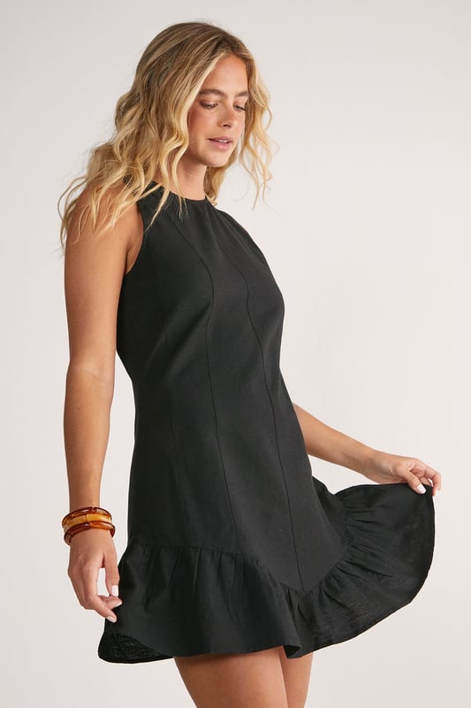 Sleeveless design with high neckline for a sophisticated silhouette
        Vertical seam detailing creates a flattering structured shape
        Playful peplum hem adds movement and feminine flair
        Linen mix fabric offers breathable comfort with natural texture
        Mini length perfect for showcasing legs and statement footwear
    
    This charming mini dress combines simplicity with thoughtful design elements for effortless daytime style. The structured seaming creates a flattering shape that flows into a flirty peplum hem, adding just the right amount of movement as you walk. Style with western boots for a contemporary countryside look, or pair with trainers and an oversized denim jacket for casual weekend brunches. The breathable linen mix fabric makes it ideal for warm-weather gatherings, whilst the versatile high neckline works beautifully with layered necklaces or statement earrings. Perfect for family barbecues, farmers' markets or seaside strolls, this NastyGal dress transitions seamlessly from day to evening with a simple change of accessories.