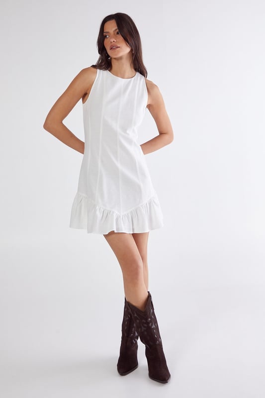 Sleeveless design with high neckline for a sophisticated silhouette
        Vertical seam detailing creates a flattering structured shape
        Playful peplum hem adds movement and feminine flair
        Linen mix fabric offers breathable comfort with natural texture
        Mini length perfect for showcasing legs and statement footwear
    
    This charming mini dress combines simplicity with thoughtful design elements for effortless daytime style. The structured seaming creates a flattering shape that flows into a flirty peplum hem, adding just the right amount of movement as you walk. Style with western boots for a contemporary countryside look, or pair with trainers and an oversized denim jacket for casual weekend brunches. The breathable linen mix fabric makes it ideal for warm-weather gatherings, whilst the versatile high neckline works beautifully with layered necklaces or statement earrings. Perfect for family barbecues, farmers' markets or seaside strolls, this NastyGal dress transitions seamlessly from day to evening with a simple change of accessories.