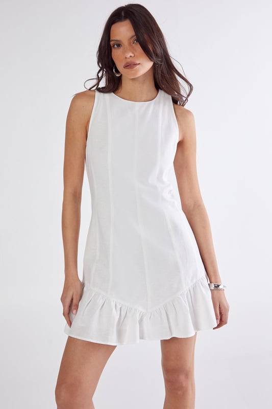 Sleeveless design with high neckline for a sophisticated silhouette
        Vertical seam detailing creates a flattering structured shape
        Playful peplum hem adds movement and feminine flair
        Linen mix fabric offers breathable comfort with natural texture
        Mini length perfect for showcasing legs and statement footwear
    
    This charming mini dress combines simplicity with thoughtful design elements for effortless daytime style. The structured seaming creates a flattering shape that flows into a flirty peplum hem, adding just the right amount of movement as you walk. Style with western boots for a contemporary countryside look, or pair with trainers and an oversized denim jacket for casual weekend brunches. The breathable linen mix fabric makes it ideal for warm-weather gatherings, whilst the versatile high neckline works beautifully with layered necklaces or statement earrings. Perfect for family barbecues, farmers' markets or seaside strolls, this NastyGal dress transitions seamlessly from day to evening with a simple change of accessories.