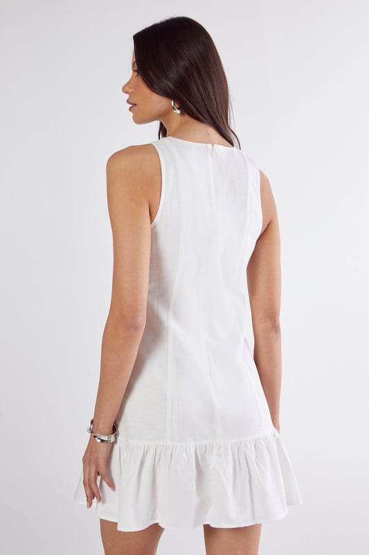Sleeveless design with high neckline for a sophisticated silhouette
        Vertical seam detailing creates a flattering structured shape
        Playful peplum hem adds movement and feminine flair
        Linen mix fabric offers breathable comfort with natural texture
        Mini length perfect for showcasing legs and statement footwear
    
    This charming mini dress combines simplicity with thoughtful design elements for effortless daytime style. The structured seaming creates a flattering shape that flows into a flirty peplum hem, adding just the right amount of movement as you walk. Style with western boots for a contemporary countryside look, or pair with trainers and an oversized denim jacket for casual weekend brunches. The breathable linen mix fabric makes it ideal for warm-weather gatherings, whilst the versatile high neckline works beautifully with layered necklaces or statement earrings. Perfect for family barbecues, farmers' markets or seaside strolls, this NastyGal dress transitions seamlessly from day to evening with a simple change of accessories.