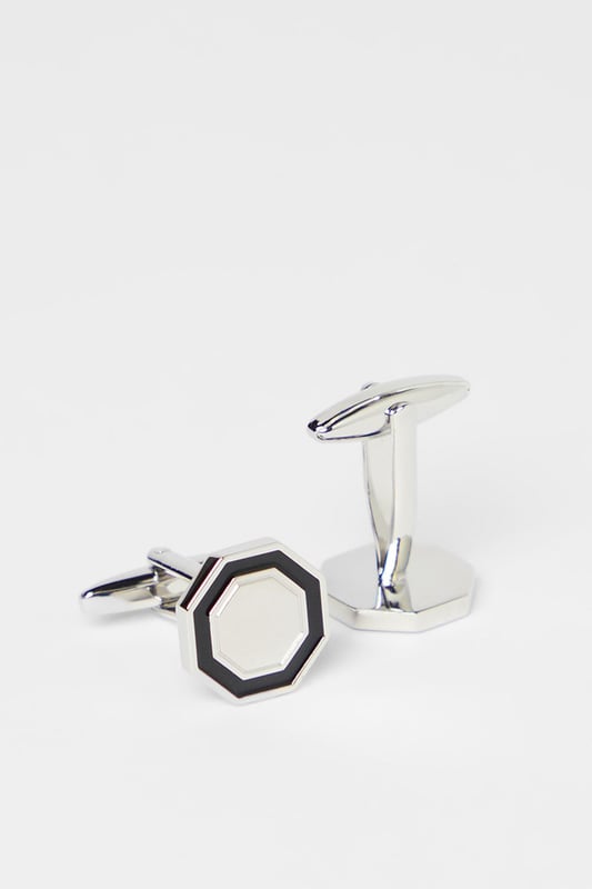 Distinctive hexagonal design for a contemporary twist on classic cufflinks
        Two-tone metal finish creates a sophisticated contrast
        Secure fastening mechanism ensures they stay in place throughout the day
        Polished metal surface reflects light for subtle sophistication
        Versatile size suitable for both standard and French cuff shirts
    
    These striking hexagon cufflinks from Burton offer the perfect finishing touch to your formal attire. The bold geometric design presents a modern interpretation of traditional cufflinks whilst maintaining a timeless appeal. Pair with a crisp white shirt for important meetings or job interviews to convey attention to detail. For evening events, these cufflinks complement a classic dinner suit brilliantly, adding just the right amount of personality without overwhelming your ensemble. The contrasting silver and black elements make them remarkably versatile, working seamlessly with various shirt colours and suit styles. Whether you're attending a wedding, important business meeting or simply want to sharpen up your office attire, these cufflinks provide that refined touch that demonstrates sartorial confidence. A subtle yet impactful way to express your style whilst maintaining professional decorum.