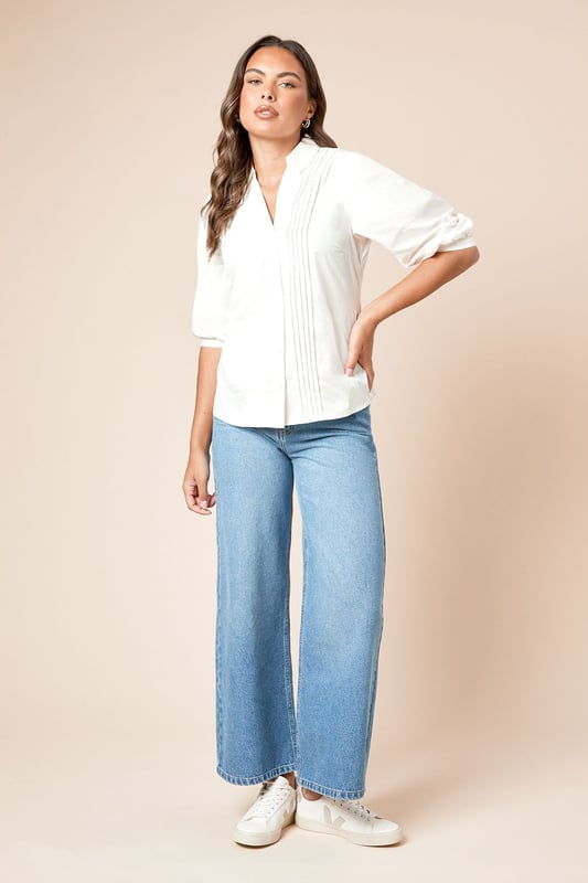 Elegant pintuck detailing along the front creates a refined texture and visual interest
        Classic collared neckline offers a smart, polished finish
        Three-quarter length sleeves with subtle volume for comfortable movement
        Button-through front design for versatile styling options
        Lightweight poplin fabric ensures breathability and comfort for all-day wear
    
    This Dorothy Perkins poplin shirt combines timeless sophistication with contemporary styling. The distinctive pintuck detailing adds subtle texture whilst maintaining a clean, refined aesthetic. Perfect for casual gatherings, style with wide-leg denim trousers and white trainers for a relaxed weekend brunch with friends. For family occasions, pair with tailored trousers and ballet flats for an effortlessly chic ensemble. The versatile design transitions seamlessly from day to evening - simply tuck into a midi skirt and add delicate jewellery for dinner dates. The crisp collared neckline frames the face beautifully, whilst the three-quarter length sleeves offer a flattering silhouette. This wardrobe essential works across seasons, layering comfortably under jumpers in cooler months or standing alone as a sophisticated staple during warmer weather.