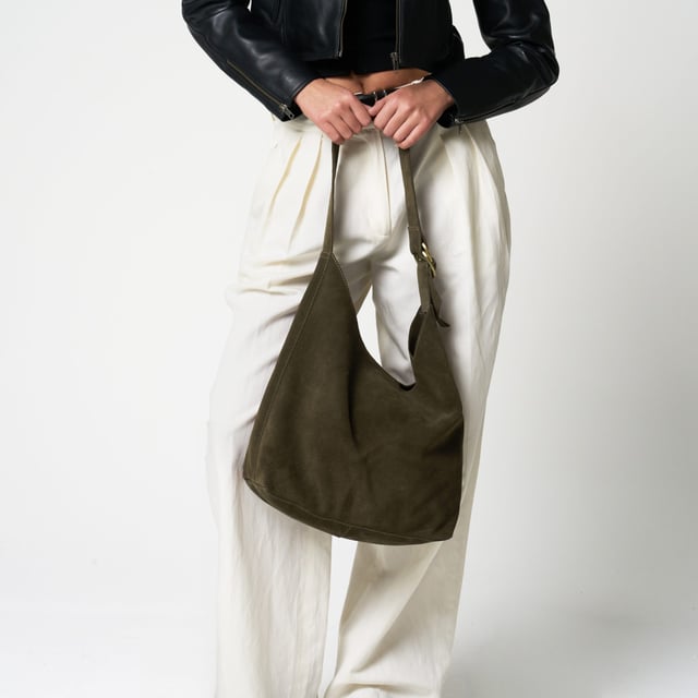 Add effortless elegance to your everyday wardrobe with this beautifully understated suede shoulder bag from Barneys Originals. Crafted from 100% real cow suede, this slouchy silhouette is soft to the touch and perfect for summer styling. 

Designed with practicality in mind, this bag features an adjustable shoulder strap and a roomy interior for all your essentials. The worn-effect gold hardware adds a timeless touch that only gets better with age.

Key Features:

Made from 100% real cow suede

Soft, unstructured shape for a relaxed feel

Adjustable shoulder strap with gold-tone hardware

Magnetic fastening for easy access

Spacious enough for your everyday must-haves

Dimensions:
Height: 10" (25.4 cm)
Width: 15" (38.1 cm)
Handle Drop: 13" (33 cm)