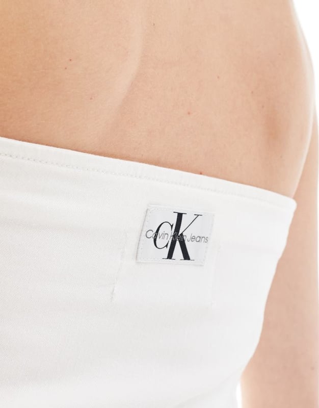 Tops by Calvin Klein Jeans  Skirt and jacket sold separately Bandeau style Logo patch to back Zip fastening Slim fitSold By: Asos