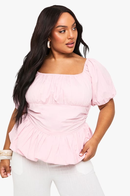 Crafted from breathable cotton poplin for all-day comfort
        Feminine square neckline with delicate gathering detail
        Statement puff sleeves add a romantic touch
        Flattering peplum hem creates a beautiful silhouette
        Designed with inclusive sizing for the perfect plus-size fit
    
    This charming cotton blouse combines contemporary style with classic femininity. The gathered square neckline frames your dcolletage beautifully, while the voluminous puff sleeves create a balanced silhouette that's both on-trend and timelessly elegant. The peplum hem adds definition to your waistline and pairs wonderfully with high-waisted trousers as styled on our model. Perfect for casual daytime events, family gatherings or weekend brunches, this versatile Boohoo blouse can be dressed up with statement earrings and wide-leg trousers for a chic ensemble, or paired with your favourite denim and trainers for a more relaxed look. The lightweight cotton fabric ensures comfort throughout the day, making this a wardrobe essential for the fashion-forward woman who values both style and practicality.