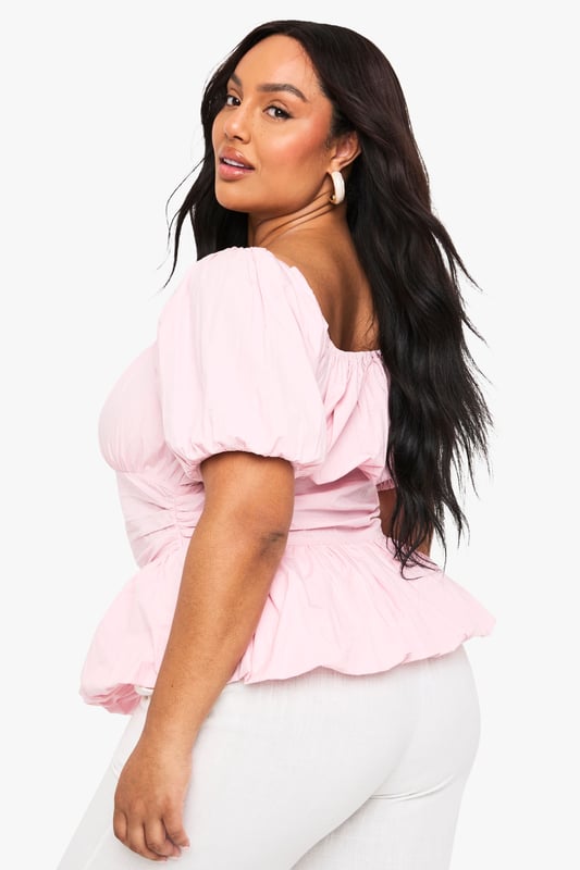 Crafted from breathable cotton poplin for all-day comfort
        Feminine square neckline with delicate gathering detail
        Statement puff sleeves add a romantic touch
        Flattering peplum hem creates a beautiful silhouette
        Designed with inclusive sizing for the perfect plus-size fit
    
    This charming cotton blouse combines contemporary style with classic femininity. The gathered square neckline frames your dcolletage beautifully, while the voluminous puff sleeves create a balanced silhouette that's both on-trend and timelessly elegant. The peplum hem adds definition to your waistline and pairs wonderfully with high-waisted trousers as styled on our model. Perfect for casual daytime events, family gatherings or weekend brunches, this versatile Boohoo blouse can be dressed up with statement earrings and wide-leg trousers for a chic ensemble, or paired with your favourite denim and trainers for a more relaxed look. The lightweight cotton fabric ensures comfort throughout the day, making this a wardrobe essential for the fashion-forward woman who values both style and practicality.