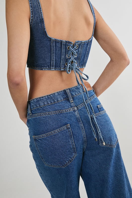 Striking denim corset top with square neckline
        Flattering structured bodice with vertical seam detailing
        Wide shoulder straps for added support and comfort
        Eye-catching lace-up back detail for adjustable fit
        Cropped length perfect for layering or wearing solo
    
    Make a bold statement with this edgy denim corset top from NastyGal. The structured bodice and vertical seaming create a figure-hugging silhouette that flatters your curves, while the square neckline adds a touch of sophistication. The standout feature is the alluring lace-up back, allowing for a customised fit and adding a rebellious flair to your ensemble. Style this versatile piece for casual outings by pairing it with high-waisted wide-leg jeans and trainers for a trendy street-style look. For a night out with friends, team it with a leather mini skirt and ankle boots to amp up the attitude. The cropped length makes it ideal for layering under an oversized blazer or wearing on its own during warmer months. This denim corset top is a must-have addition to any fashion-forward wardrobe, offering endless styling possibilities for various casual occasions.