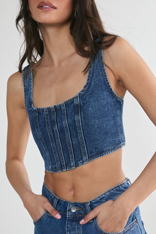 Striking denim corset top with square neckline
        Flattering structured bodice with vertical seam detailing
        Wide shoulder straps for added support and comfort
        Eye-catching lace-up back detail for adjustable fit
        Cropped length perfect for layering or wearing solo
    
    Make a bold statement with this edgy denim corset top from NastyGal. The structured bodice and vertical seaming create a figure-hugging silhouette that flatters your curves, while the square neckline adds a touch of sophistication. The standout feature is the alluring lace-up back, allowing for a customised fit and adding a rebellious flair to your ensemble. Style this versatile piece for casual outings by pairing it with high-waisted wide-leg jeans and trainers for a trendy street-style look. For a night out with friends, team it with a leather mini skirt and ankle boots to amp up the attitude. The cropped length makes it ideal for layering under an oversized blazer or wearing on its own during warmer months. This denim corset top is a must-have addition to any fashion-forward wardrobe, offering endless styling possibilities for various casual occasions.