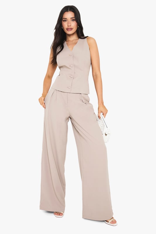 Tall wide leg trousers with elegant front pleats for added dimension and movement
        High-rise waistband with subtle stretch for all-night comfort
        Flowing wide leg silhouette creates a dramatic, fashion-forward profile
        Practical side pockets perfectly positioned for convenience
        Designed specifically for taller frames with extended length for proper fit
    
    Make a statement with these sophisticated wide leg trousers, designed with the taller fashionista in mind. The front pleating adds a touch of tailored refinement whilst the flowing wide leg cut creates a dramatic silhouette that commands attention. Perfect for evening socials, pair with the matching button-front top as shown for a coordinated ensemble that works brilliantly for drinks at upscale venues. For club nights, style with strappy heels and a cropped top to showcase the high waistband. The versatile design transitions effortlessly from casual drinks to more glamorous affairs-simply switch your accessories to match the occasion. These trousers offer the perfect balance of comfort and style for the Boohoo girl who wants to stand out whilst dancing the night away.