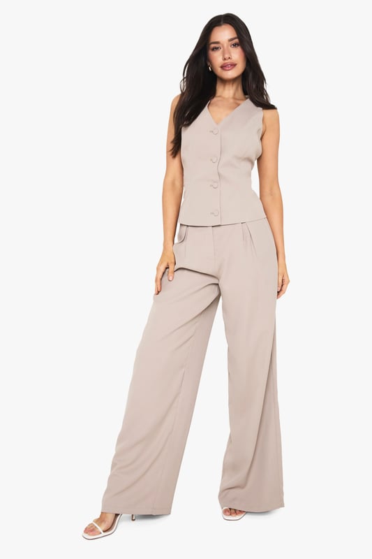 Tall wide leg trousers with elegant front pleats for added dimension and movement
        High-rise waistband with subtle stretch for all-night comfort
        Flowing wide leg silhouette creates a dramatic, fashion-forward profile
        Practical side pockets perfectly positioned for convenience
        Designed specifically for taller frames with extended length for proper fit
    
    Make a statement with these sophisticated wide leg trousers, designed with the taller fashionista in mind. The front pleating adds a touch of tailored refinement whilst the flowing wide leg cut creates a dramatic silhouette that commands attention. Perfect for evening socials, pair with the matching button-front top as shown for a coordinated ensemble that works brilliantly for drinks at upscale venues. For club nights, style with strappy heels and a cropped top to showcase the high waistband. The versatile design transitions effortlessly from casual drinks to more glamorous affairs-simply switch your accessories to match the occasion. These trousers offer the perfect balance of comfort and style for the Boohoo girl who wants to stand out whilst dancing the night away.
