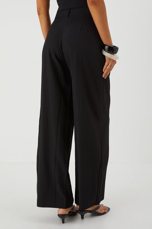 Distinctive crinkle textured fabric adding visual interest and dimension
        Flattering wide leg silhouette that creates a dramatic flowing effect
        Practical side pockets for convenience and functionality
        Front pleating detail that adds structure and sophistication
        High-rise waistband designed to enhance your natural shape
    
    Make a statement with these eye-catching crinkle textured wide leg trousers from MissPap. The dramatic flowing silhouette creates movement with every step whilst the high-rise waistband accentuates your waist for a flattering fit. Style with a fitted crop top as shown for a balanced silhouette that's perfect for casual gatherings. For daytime outings, pair with a simple tee and trainers for an effortlessly cool look. When evening approaches, switch to a bodysuit and strappy heels to transform your ensemble. The versatile design works brilliantly for family gatherings or brunches with friends, whilst the textured fabric adds a distinctive touch that sets these trousers apart from basic styles. The practical side pockets add functionality to this fashion-forward piece that will quickly become a wardrobe favourite.