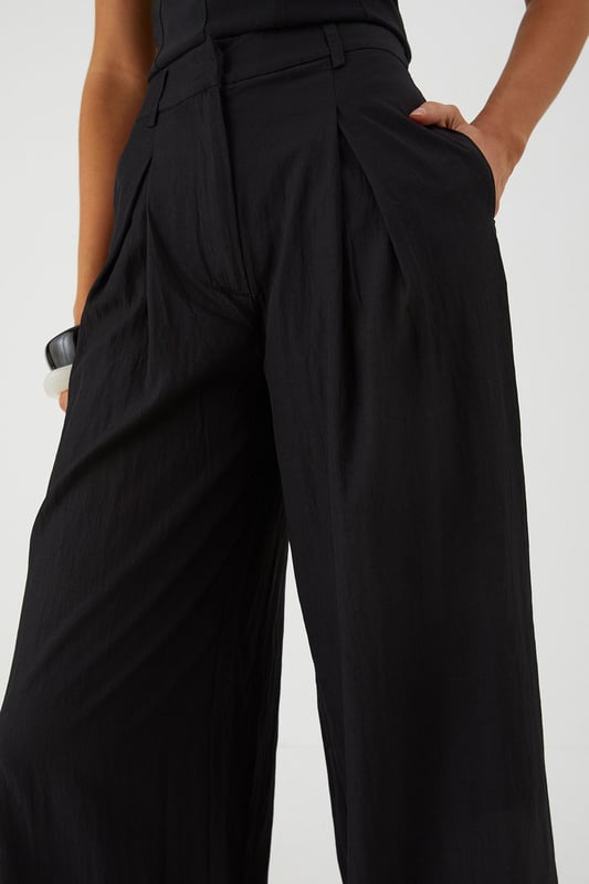 Distinctive crinkle textured fabric adding visual interest and dimension
        Flattering wide leg silhouette that creates a dramatic flowing effect
        Practical side pockets for convenience and functionality
        Front pleating detail that adds structure and sophistication
        High-rise waistband designed to enhance your natural shape
    
    Make a statement with these eye-catching crinkle textured wide leg trousers from MissPap. The dramatic flowing silhouette creates movement with every step whilst the high-rise waistband accentuates your waist for a flattering fit. Style with a fitted crop top as shown for a balanced silhouette that's perfect for casual gatherings. For daytime outings, pair with a simple tee and trainers for an effortlessly cool look. When evening approaches, switch to a bodysuit and strappy heels to transform your ensemble. The versatile design works brilliantly for family gatherings or brunches with friends, whilst the textured fabric adds a distinctive touch that sets these trousers apart from basic styles. The practical side pockets add functionality to this fashion-forward piece that will quickly become a wardrobe favourite.