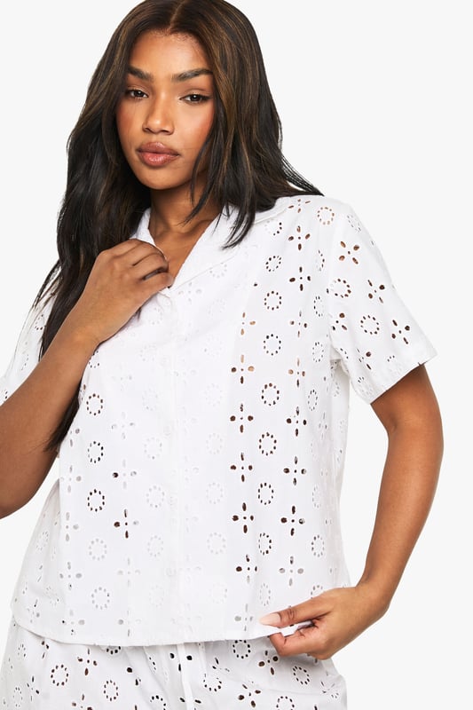 Delicate broderie anglaise pattern throughout both shirt and shorts
        Classic collared shirt design with button-through front
        Relaxed short-sleeve silhouette for comfortable movement
        Matching shorts with comfortable elastic waistband
        Lightweight fabric perfect for warmer nights
    
    Drift into dreamland in style with this charming short-sleeve pyjama set. The intricate broderie anglaise detailing adds a touch of feminine elegance to your nightwear collection, whilst the classic shirt design with collar creates a put-together look even as you unwind. The relaxed fit ensures unrestricted movement throughout the night, whilst the matching shorts complete this coordinated set beautifully. Perfect for summer evenings or those who prefer to stay cool whilst sleeping, this set also makes for a lovely loungewear option for lazy weekend mornings. Pair with your favourite slippers and a lightweight dressing gown for those midnight kitchen trips, or simply enjoy the comfort of this beautiful set on its own as you settle in with a good book before bedtime.