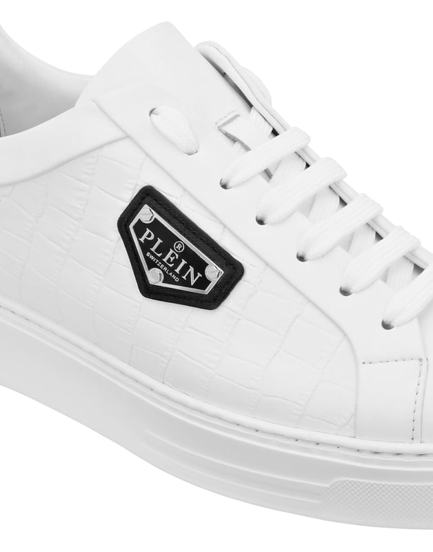 Diese raffinierten und doch unbestreitbar gewagten Low-Top-Sneaker vereinen hochwertige Handwerkskunst mit auffälligen Designelementen und sind perfekt, um jedem Ensemble einen Hauch von Luxus zu verleihen.    Vollständig aus hochwertigem Kalbsleder gefertigt für ein raffiniertes, geschmeidiges Gefühl.   Das charakteristische Sechseck-Emblem setzt einen unverwechselbaren, luxuriösen Akzent.   Futter und Innensohle aus Kalbsleder bieten höchsten Komfort und Atmungsaktivität.   Die robuste Gummilaufsohle sorgt für dauerhafte Haltbarkeit und Traktion.   Vielseitiges Design, ideal sowohl für lässige als auch für gehobene Stylings.