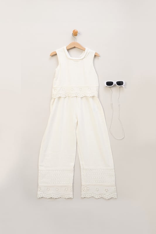 Perfect for holidays and summertime events, this adorable broderie jumpsuit by Miss features a playful scalloped edge design and crotchet panel. The set comes with matching sunglasses, creating a fun and stylish outfit that's both comfortable and versatile for sunny days.