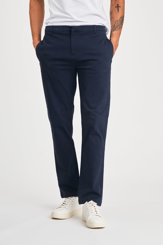 The Nines Cotton Trousers offer a classic, straight-leg fit with belt loops for a tailored look. Designed with side and back pockets for added convenience, these versatile trousers provide both style and practicality, making them a perfect addition to any wardrobe. Ideal for both casual and smart-casual wear.