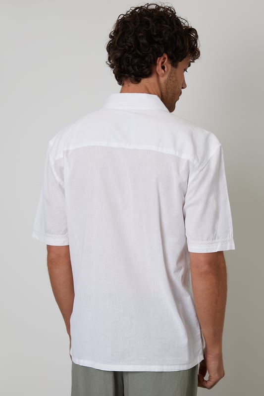 Elevate your holiday wardrobe with this cotton and linen blend short-sleeve shirt from Threadbare. Designed for the modern trendsetter, this relaxed-fit shirt has a revere collar and is made from a lightweight cotton linen blend fabric perfect for the warmer weather. With crochet lace detailing on the trims for an elevated look. Wear with chino shorts and sandals for a relaxed holiday look, or smarten it up with a pair of linen blend trousers.