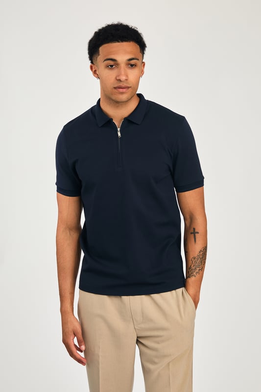 This zip-neck polo shirt from Kensington Eastside blends classic sophistication with modern design. Lightweight and breathable, it’s a versatile choice for smart-casual occasions, ensuring style and comfort effortlessly.