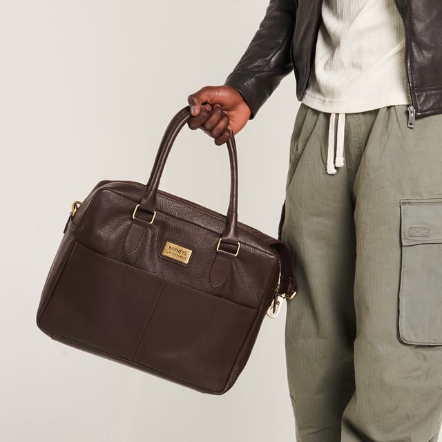 – Real leather
– Detachable shoulder strap
– Two zipped compartments
– Velcro laptop sleeve
– 14″ x 12″ x 4.5″

Commute in style with this brown leather messenger bag from Barneys Originals. Made from durable real leather, this sleek everyday essential is perfect for carrying your tech, with a padded Velcro laptop sleeve and handy inner zip pocket.

With two zipped sections to keep things organised, you can switch between the top handles and detachable shoulder strap depending on your day. Whether you’re heading to the office or a café, this bag has your back.