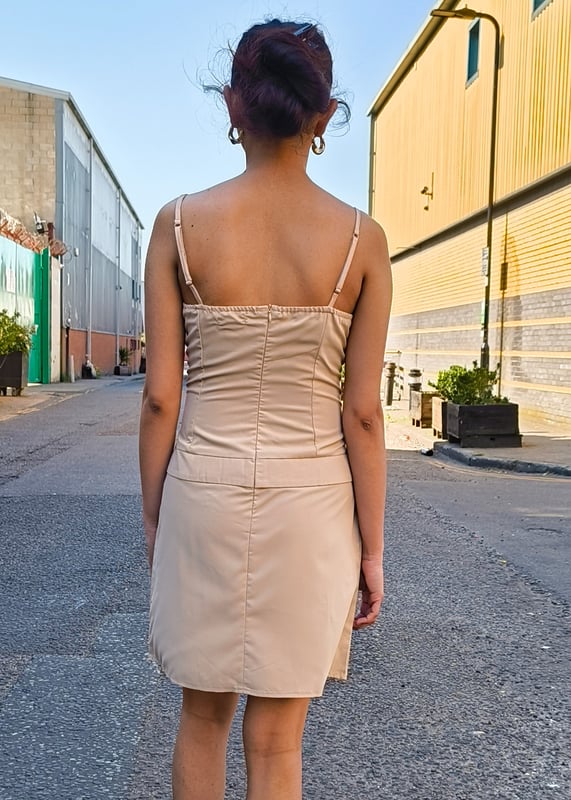 Deze beige hoge geweven minijurk is moeiteloos stijlvol en heeft geplooide details voor een comfortabele en chique pasvorm. Deze jurk is perfect voor elke gelegenheid en een must-have aanvulling op je garderobe. Zie er moeiteloos verzorgd uit en voel je zelfverzekerd in dit modieuze stuk.