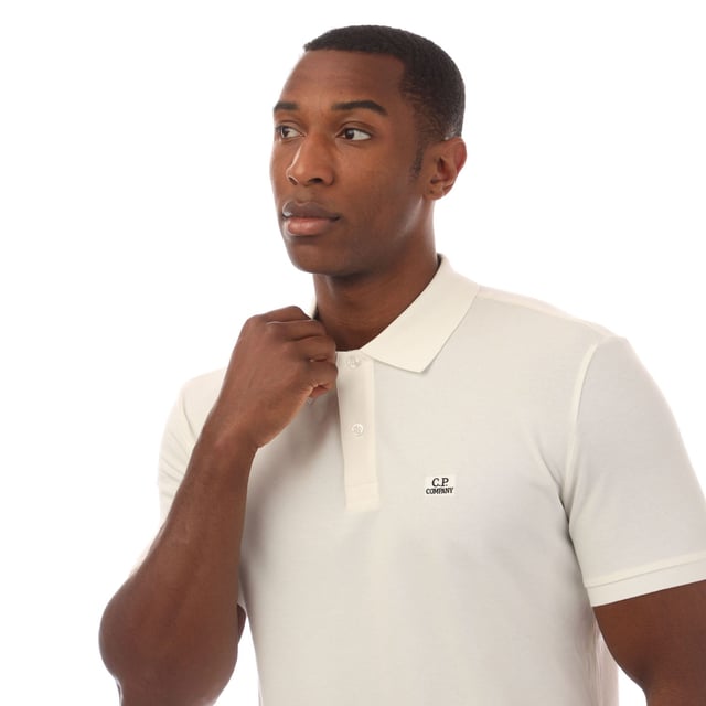 Mens C.P. Company Stretch Piquet Logo Polo Shirt in white.- Polo collar.- Short sleeves with ribbed cuffs.- Two button fastened placket.- Logo patch at the chest.- Split hem to the sides.- Straight hem.- 95% Cotton  5% Elastane.- Ref: 18CMPL065A103