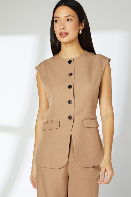 Sleek tailored waistcoat with distinctive cap sleeves for a contemporary silhouette
        Clean crew neckline complemented by statement button-through front closure
        Practical front pockets add functionality without compromising the streamlined design
        Subtle back detail with decorative buttons for added interest
        Regular fit offering comfortable movement whilst maintaining a polished appearance
    
    This versatile Principles waistcoat brings modern sophistication to your daywear collection. The clean lines and cap sleeve detail create a refined yet relaxed silhouette that works beautifully for various casual occasions. Style with the matching wide-leg trousers as shown for an effortlessly coordinated look, or pair with slim-fit denim and trainers for a smart-casual weekend ensemble. The structured woven fabric provides just enough stretch for all-day comfort, making it ideal for family gatherings or lunch with friends. Add simple gold-toned jewellery and a structured tote for a polished finish. This piece transitions seamlessly from day to evening - simply swap your flats for a block heel and add a bold lip colour for after-work drinks or dinner dates.