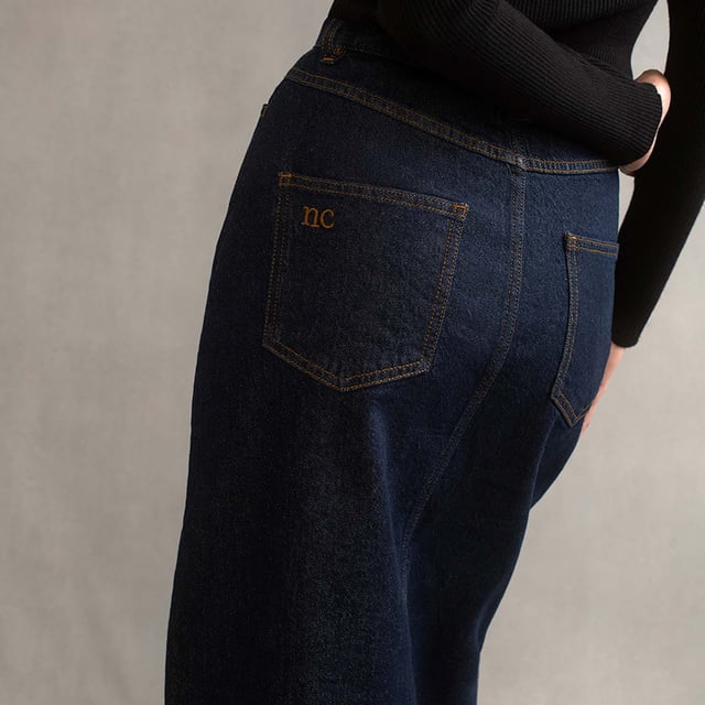 Women's Nobodys Child Denim Column Skirt. This season the iconic denim skirt has got a little longer and we’re in love. Cut to a midi column shape, this stylish new number is made in an inky indigo blue. Don’t miss the subtle NC embroidery stitched on the back pocket. Wear it with everything from tank tops to super soft knits.- Front and back pockets.- Belt loops.- Classic five pocket style.- Tobacco coloured stitching.- Copper-tone NC button.- Zip fly.- Centre slit. Material: 99% Organic Cotton, 1% Elastane. Ref: B231982BLU.