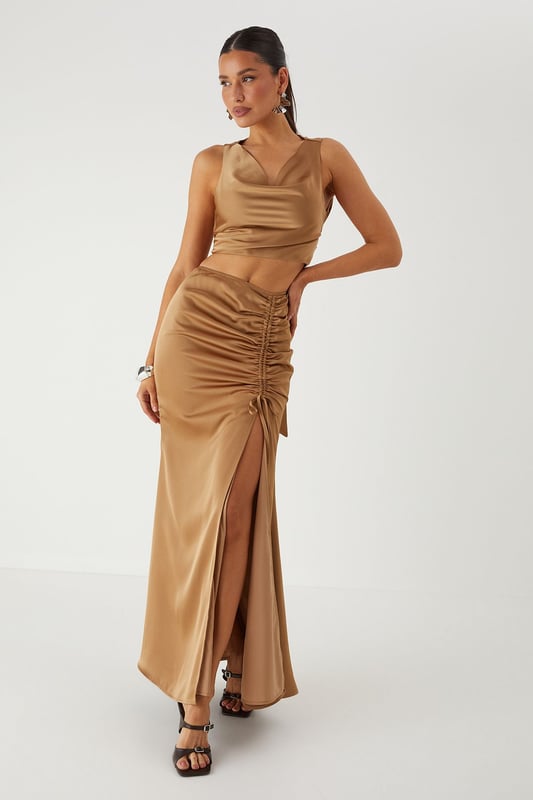 Luxurious satin co-ord featuring a flattering cowl neckline top and statement maxi skirt
        Elegant ruched detailing along the skirt front creates a figure-enhancing silhouette
        Daring side split in the maxi skirt adds movement and reveals just the right amount of leg
        Stylish tie-back detail on the top for an adjustable and secure fit
        Sleek crop top design pairs perfectly with the high-waisted maxi skirt for a contemporary two-piece look
    
    Make a striking entrance at your next special occasion in this showstopping satin co-ord from MissPap. The combination of the cowl neck crop top and ruched maxi skirt creates a contemporary silhouette that commands attention. Style with strappy heels and statement earrings as seen on our model for maximum impact at formal events. The high-waisted design of the skirt elongates your figure, whilst the side split adds a touch of drama to your movement. Perfect for weddings, graduation ceremonies or evening galas, this versatile co-ord can be dressed up with metallic accessories for a glamorous finish. For cooler evenings, layer with a tailored blazer without compromising on style. The satin fabric catches the light beautifully as you move, ensuring all eyes are on you throughout the night.